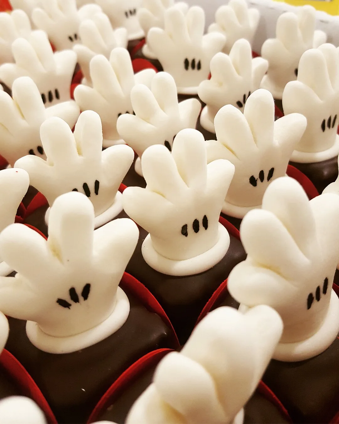 Brigadeiros da Minnie decorados com luvinhas brancas modeladas em pasta americana