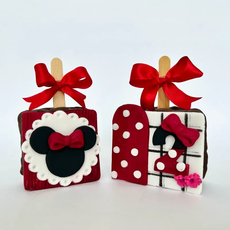 Pão de mel recheado da Minnie em palito com laço de fita vermelho, dois modelos decorados